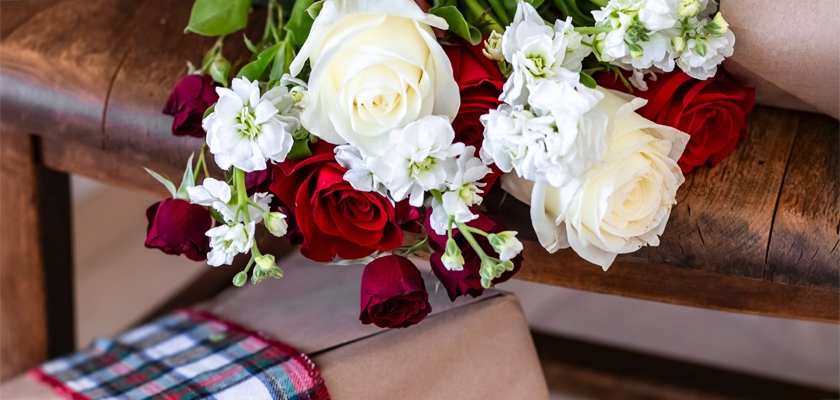 Charming floral arrangement featuring red and white roses with delicate greenery, ideal for gifts.