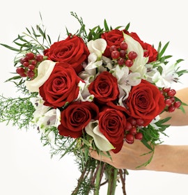 Vibrant bouquet featuring red roses, white flowers, and lush greenery, perfect for any celebration.