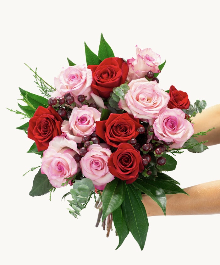 Vibrant bouquet of red and pink roses highlighted with greenery, ideal for celebrations and gifts.