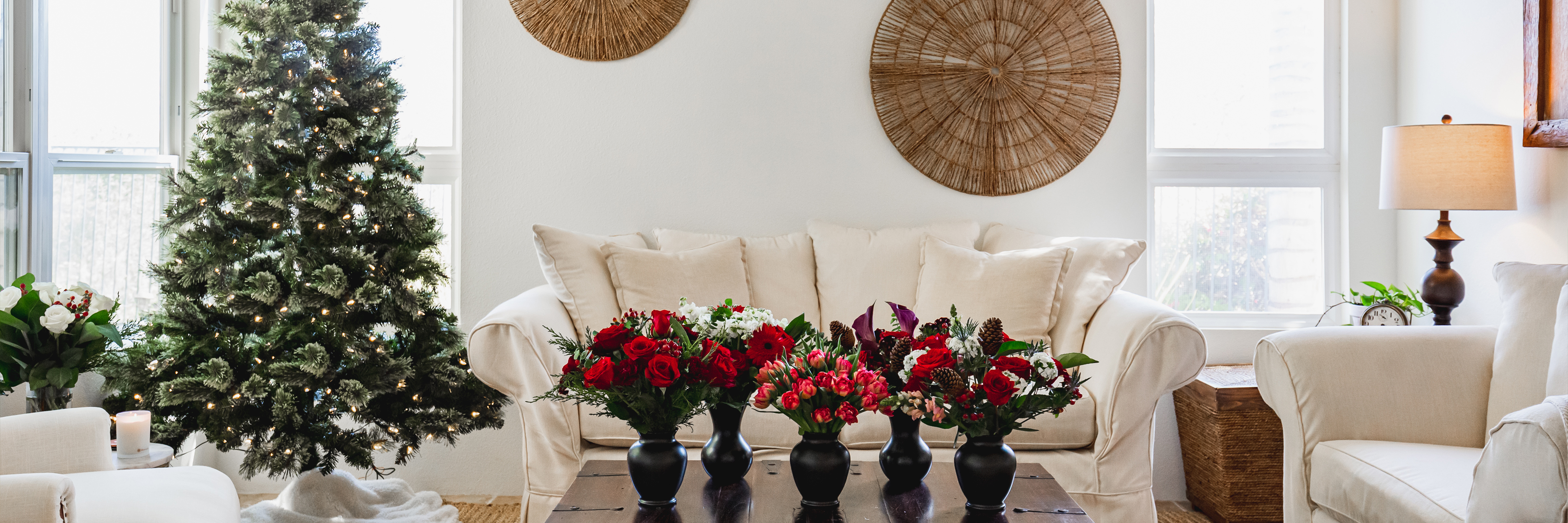 A cozy living room adorned with festive floral arrangements and a Christmas tree.
