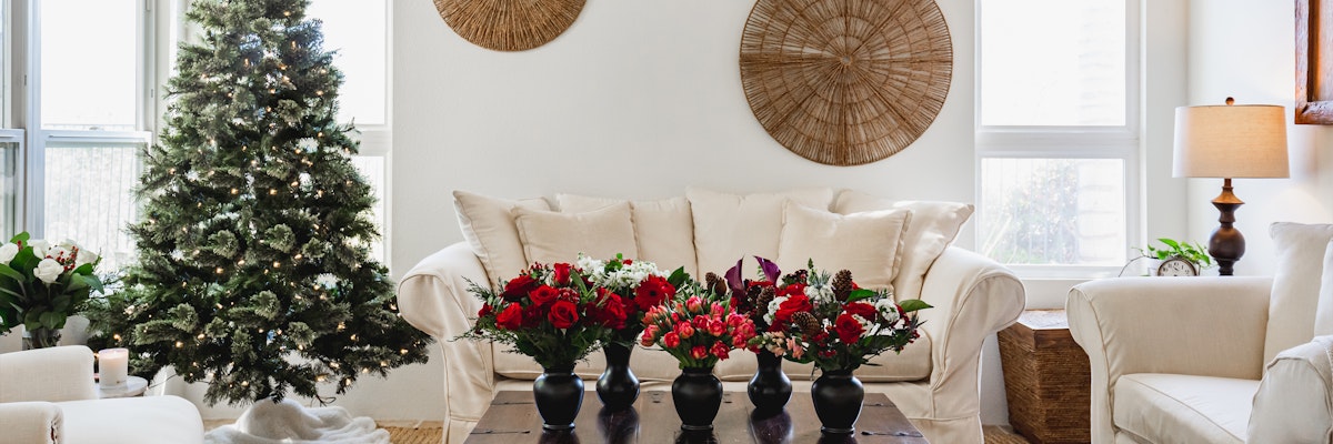 A cozy living room adorned with festive floral arrangements and a Christmas tree.