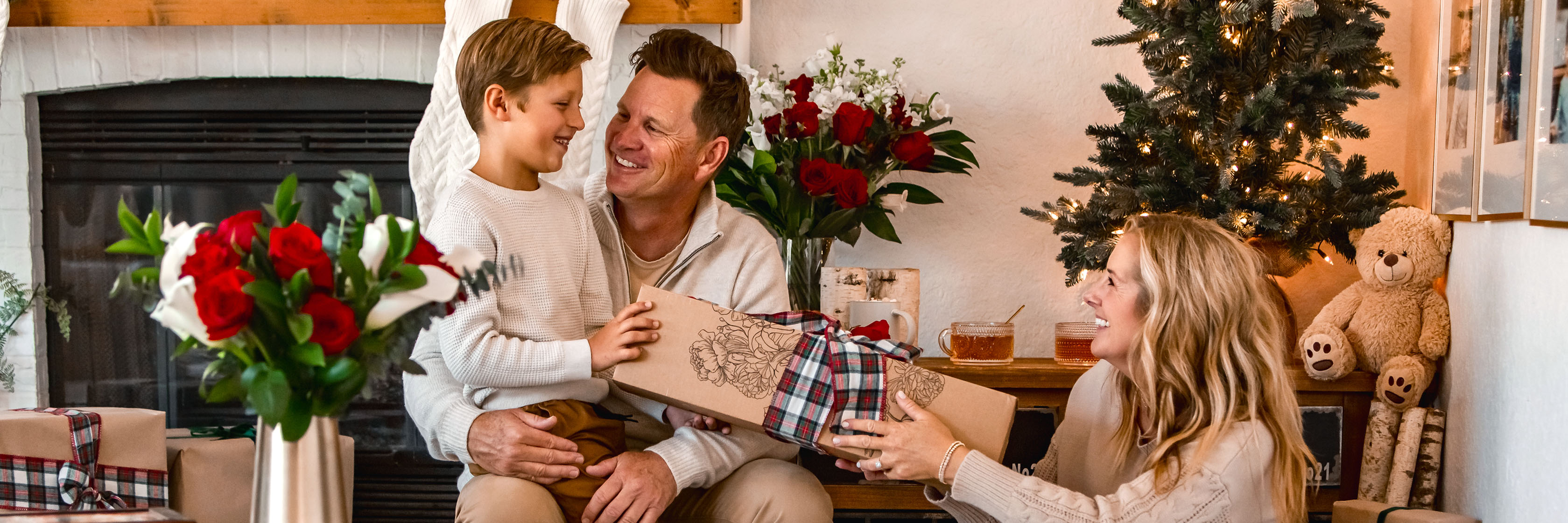 A joyful family moment by the fireplace, exchanging gifts and celebrating togetherness.