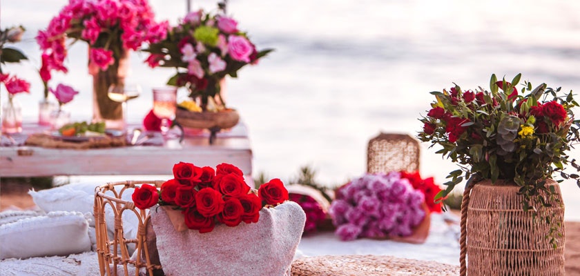 Vibrant outdoor floral setup featuring red roses and assorted blooms for a festive celebration.