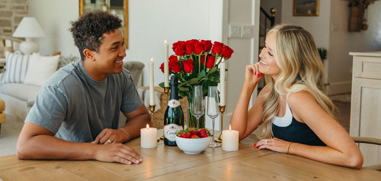 A romantic dinner setting with red roses, champagne, and candles, perfect for a special date night.