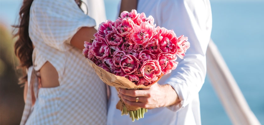 A romantic bouquet of pink tulips held by a couple, perfect for love and celebrations.
