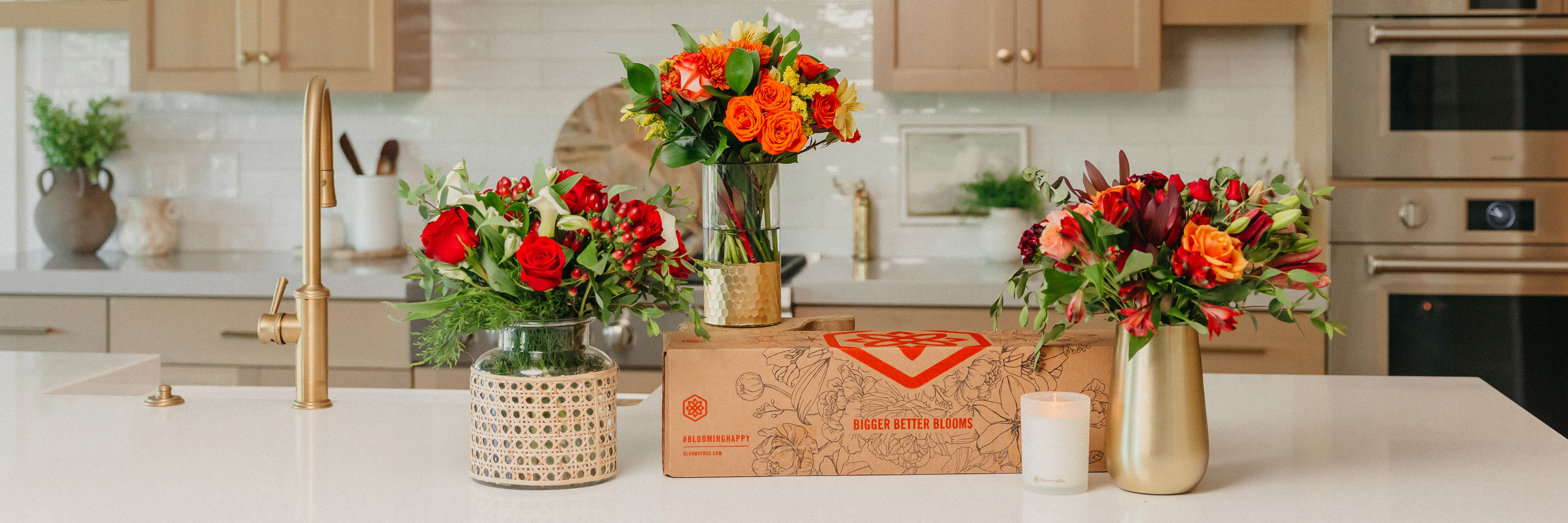 Vibrant floral arrangements featuring red, orange, and yellow blooms on a kitchen countertop.