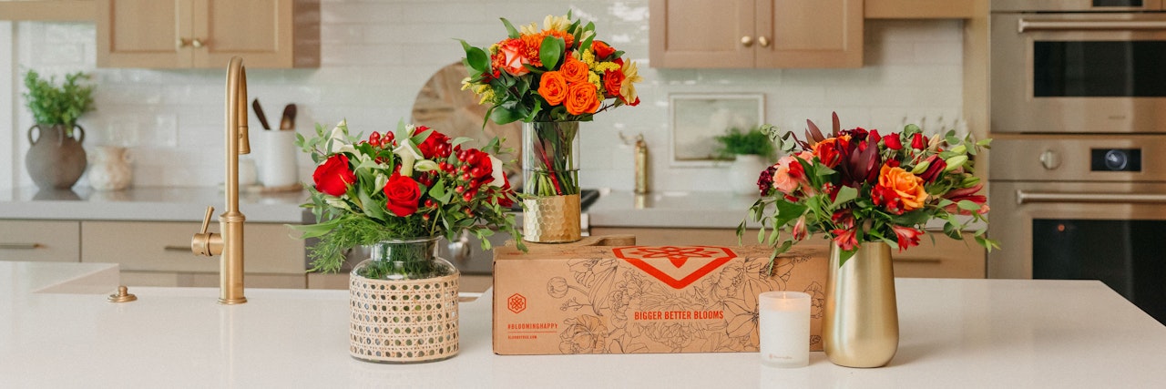 Vibrant floral arrangements featuring red, orange, and yellow blooms on a kitchen countertop.