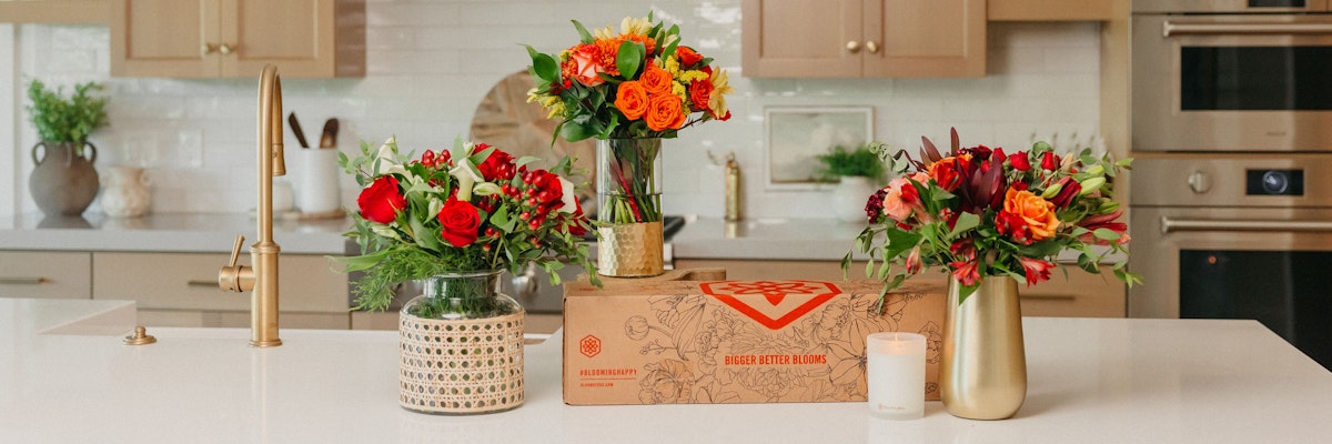 Vibrant floral arrangements featuring red, orange, and yellow blooms on a kitchen countertop.