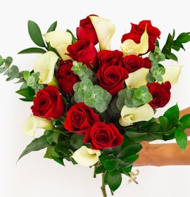 Vibrant bouquet featuring red roses and white calla lilies, beautifully arranged.
