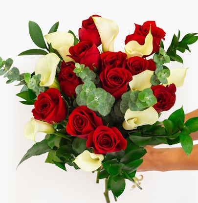 Vibrant bouquet featuring red roses and white calla lilies, beautifully arranged.