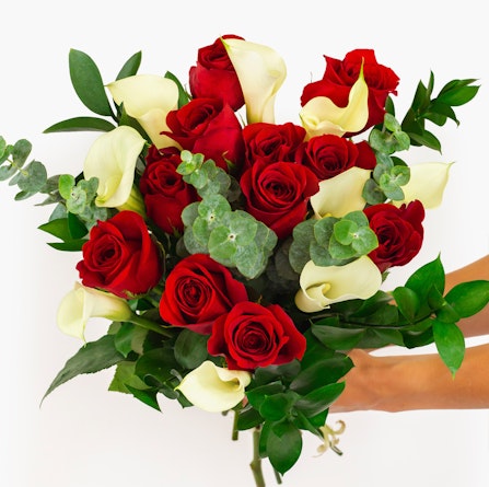 Vibrant bouquet featuring red roses and white calla lilies, beautifully arranged.