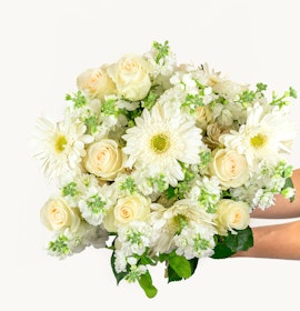 A beautiful bouquet of white roses and daisies adorned with fresh greenery, ideal for all occasions.