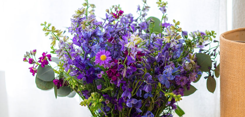 Vibrant mixed flower bouquet featuring purple blooms and lush greenery, perfect for any occasion.