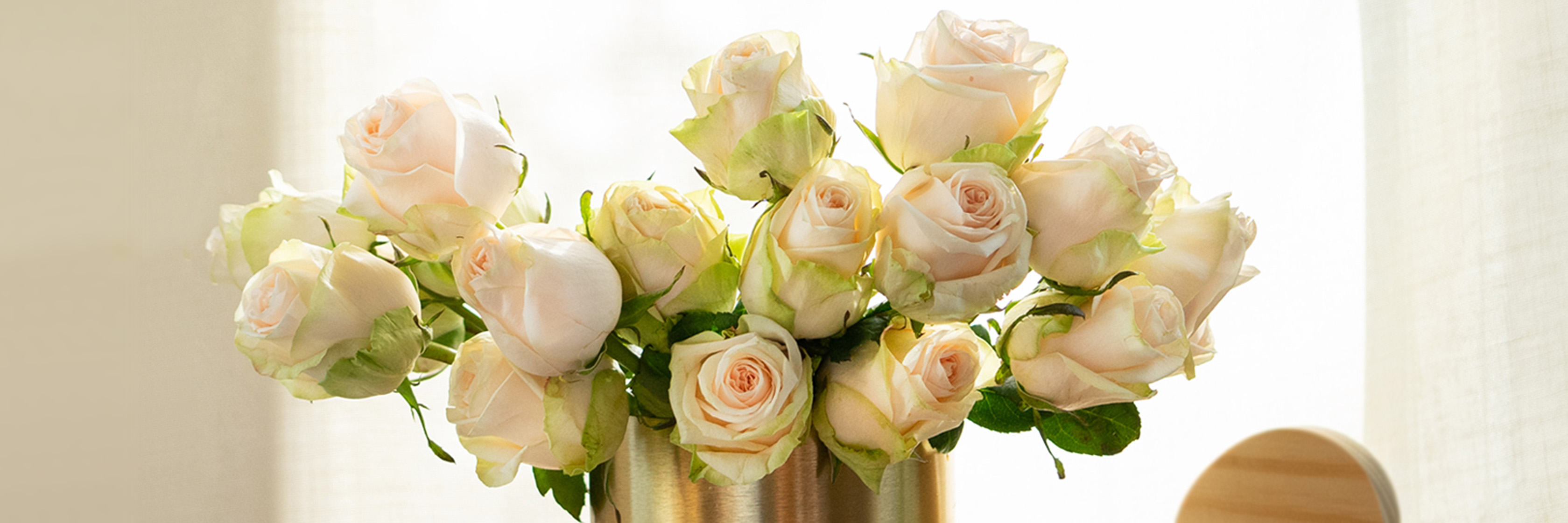 Delicate arrangement of soft pink roses in a stylish gold vase, ideal for elegant decor.