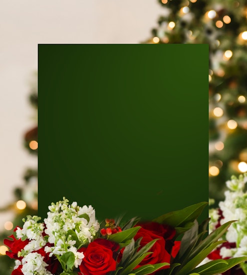 A festive arrangement featuring red roses and white flowers surrounded by lush greenery.