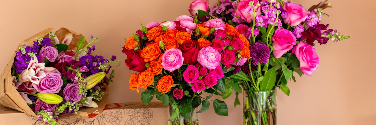 Vibrant floral display featuring colorful roses and mixed blooms in elegant vases.