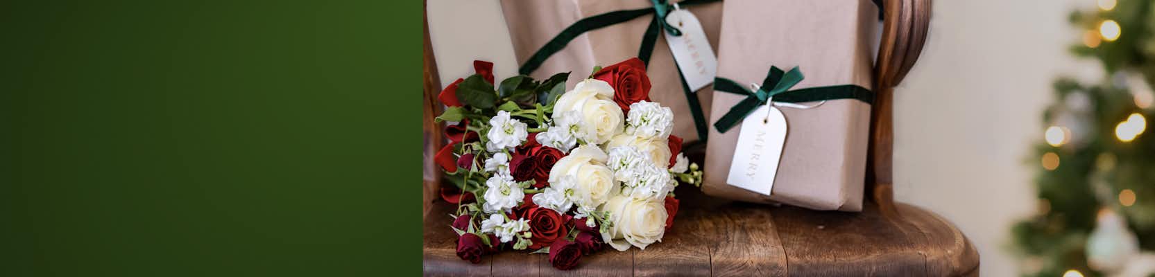 Elegant bouquet of red and white roses beside beautifully wrapped gifts, perfect for celebrations.