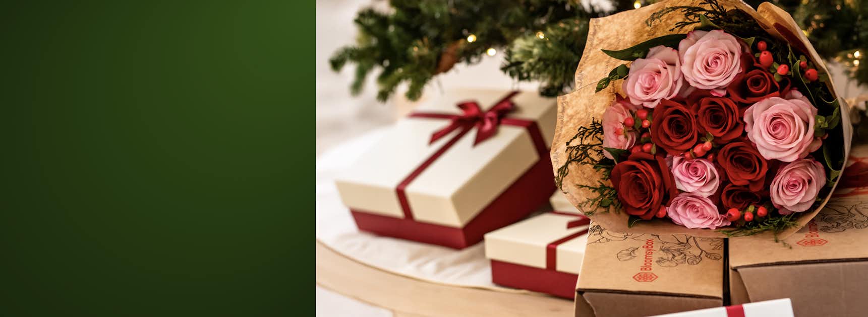 Festive bouquet of pink and red roses adorned with seasonal berries, beside elegantly wrapped gifts.