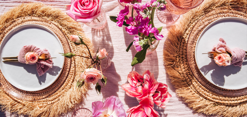 Elegant table setting featuring pink roses and vibrant flowers, perfect for special gatherings.