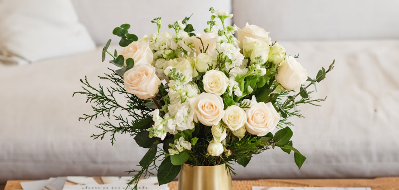Elegant bouquet of soft pink and white roses with greenery in a chic vase, perfect for any occasion.