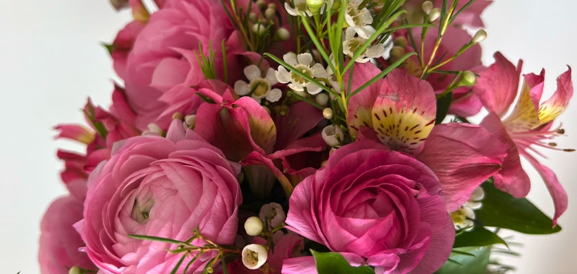 Vibrant pink floral arrangement featuring ranunculus and delicate blooms, perfect for celebrations.