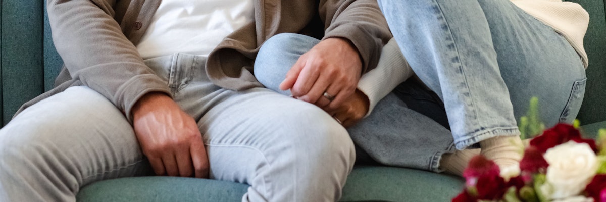 A cozy couple relaxing together on a teal couch, showcasing their connection and intimacy.
