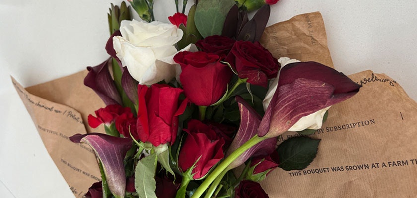 Vibrant floral arrangement featuring red and white roses with elegant calla lilies.