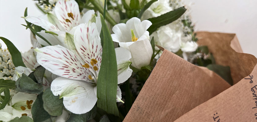 Delicate floral arrangement featuring white blooms, greenery, and rustic wrapping for a fresh look.