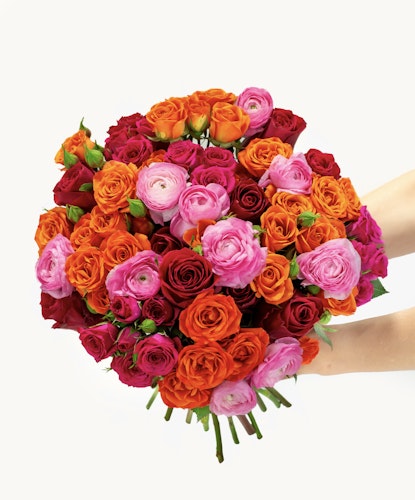 A vibrant floral arrangement featuring a mix of orange, pink, and red roses in a decorative bouquet.