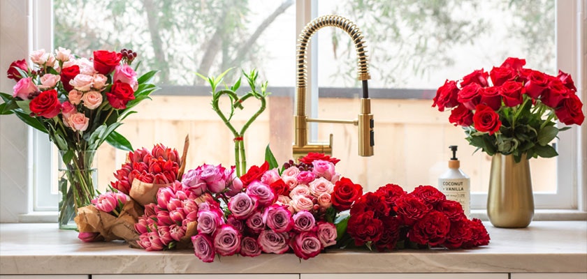 Vibrant floral display featuring assorted roses and blooms in a bright kitchen setting.