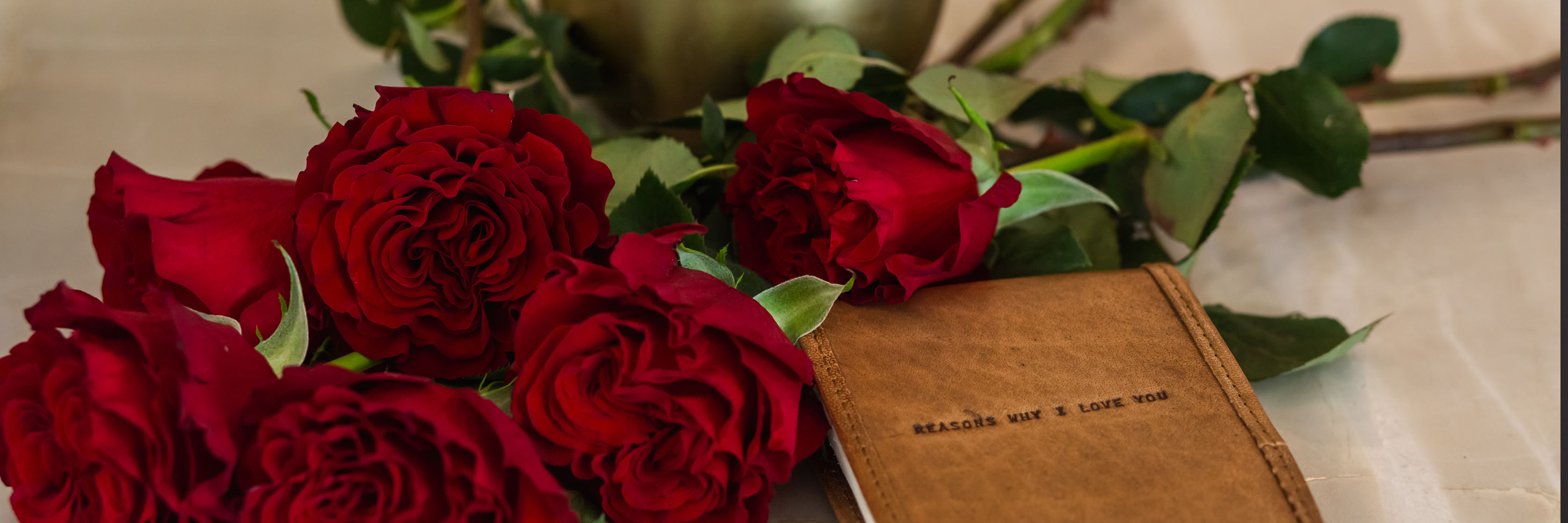 Vibrant red roses elegantly placed beside a heartfelt love note, symbolizing romance and affection.