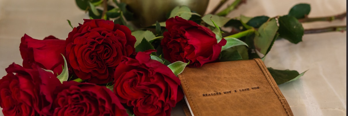 Vibrant red roses elegantly placed beside a heartfelt love note, symbolizing romance and affection.