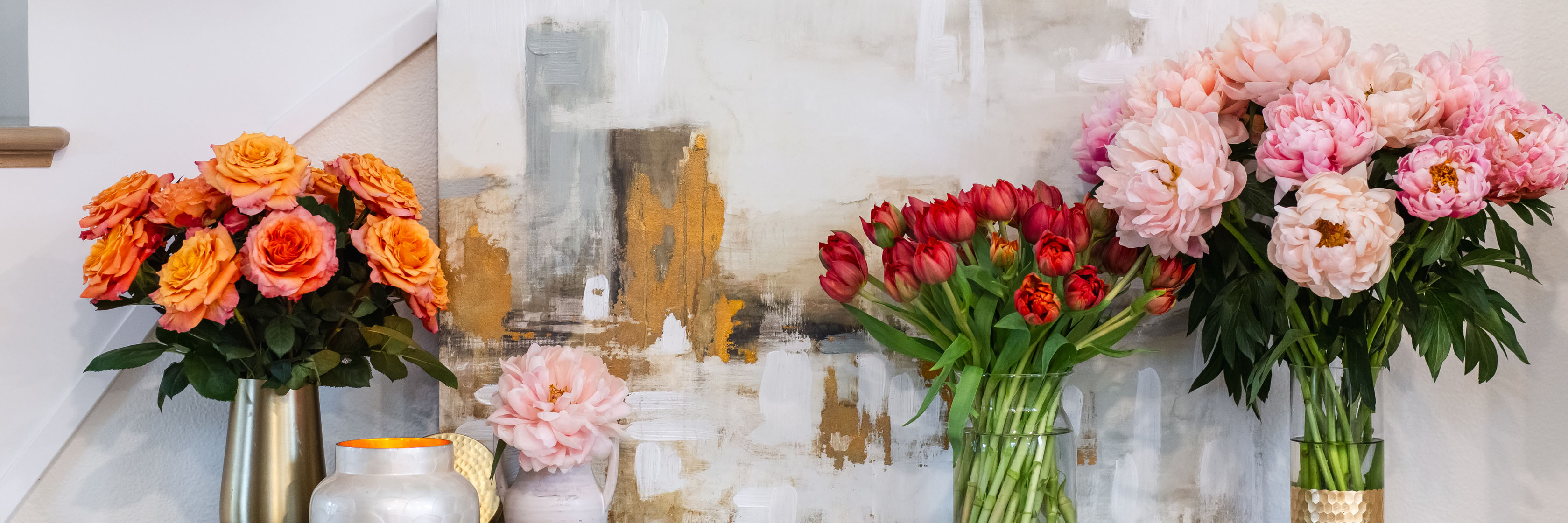 Vibrant floral arrangements featuring orange roses, pink peonies, and red tulips in elegant vases.