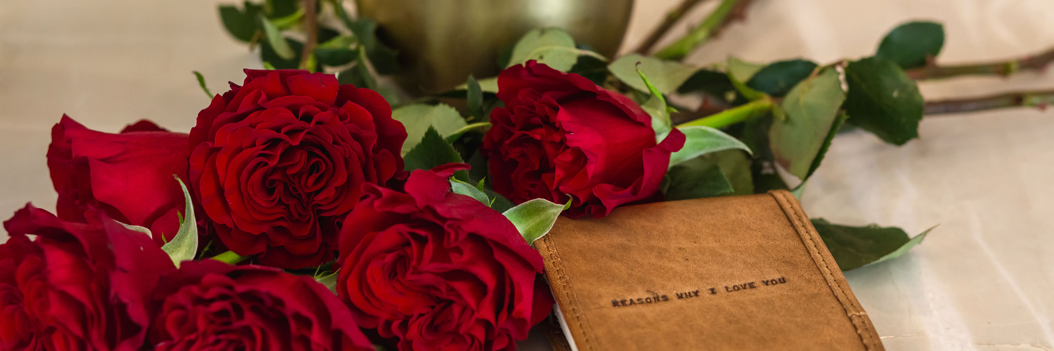 Vibrant red roses laid beside a heartfelt card, ideal for expressing love and affection.