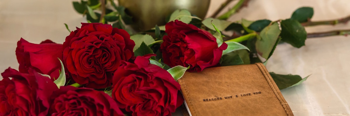 Vibrant red roses laid beside a heartfelt card, ideal for expressing love and affection.