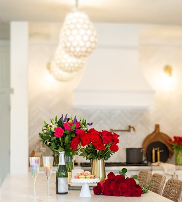 Elegant floral arrangements of roses and vibrant blooms on a kitchen counter, ready for celebration.