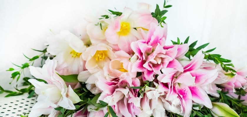 Delicate arrangement of pink lilies and white blooms with lush greenery, perfect for gifting.