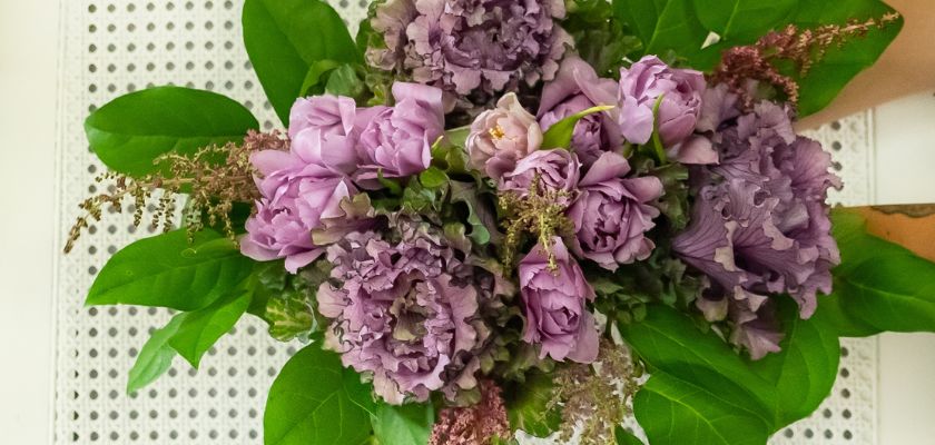 Elegant purple flower bouquet with lush green leaves, perfect for any occasion.