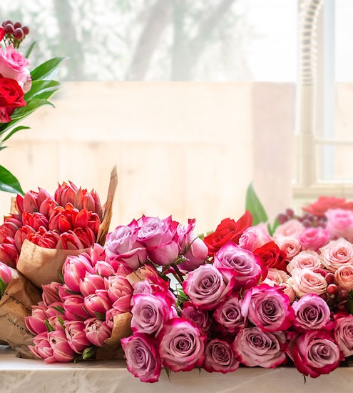 A vibrant assortment of pink and red roses and tulips arranged elegantly for any celebration.