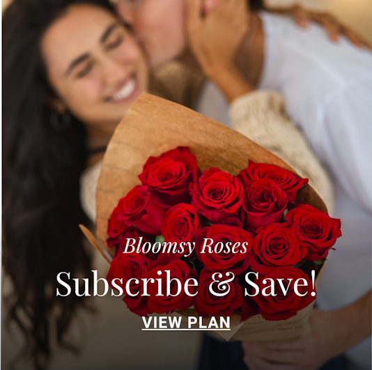 A romantic couple sharing a joyful moment with a bouquet of red roses.