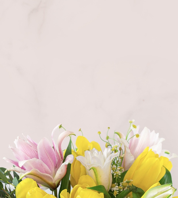 Vibrant floral arrangement featuring yellow tulips, pink lilies, and delicate greenery.