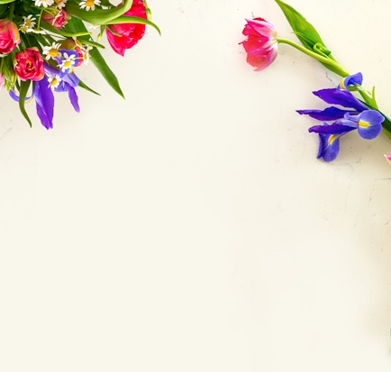 Vibrant floral arrangement featuring colorful tulips, daisies, and irises on a light background.