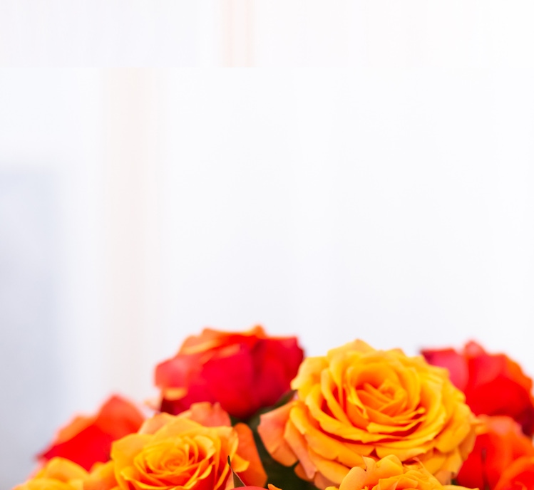 Vibrant orange and red roses create a cheerful floral bouquet, ideal for brightening any room.