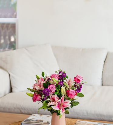 Charming floral arrangement featuring pink lilies and roses in a stylish vase, enhancing home decor.