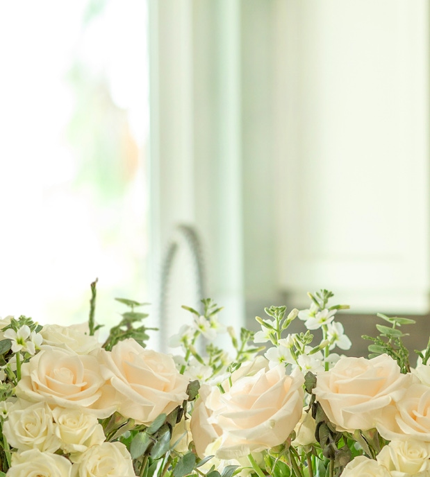 Delicate arrangement of soft peach roses and white flowers, ideal for elegant decor.