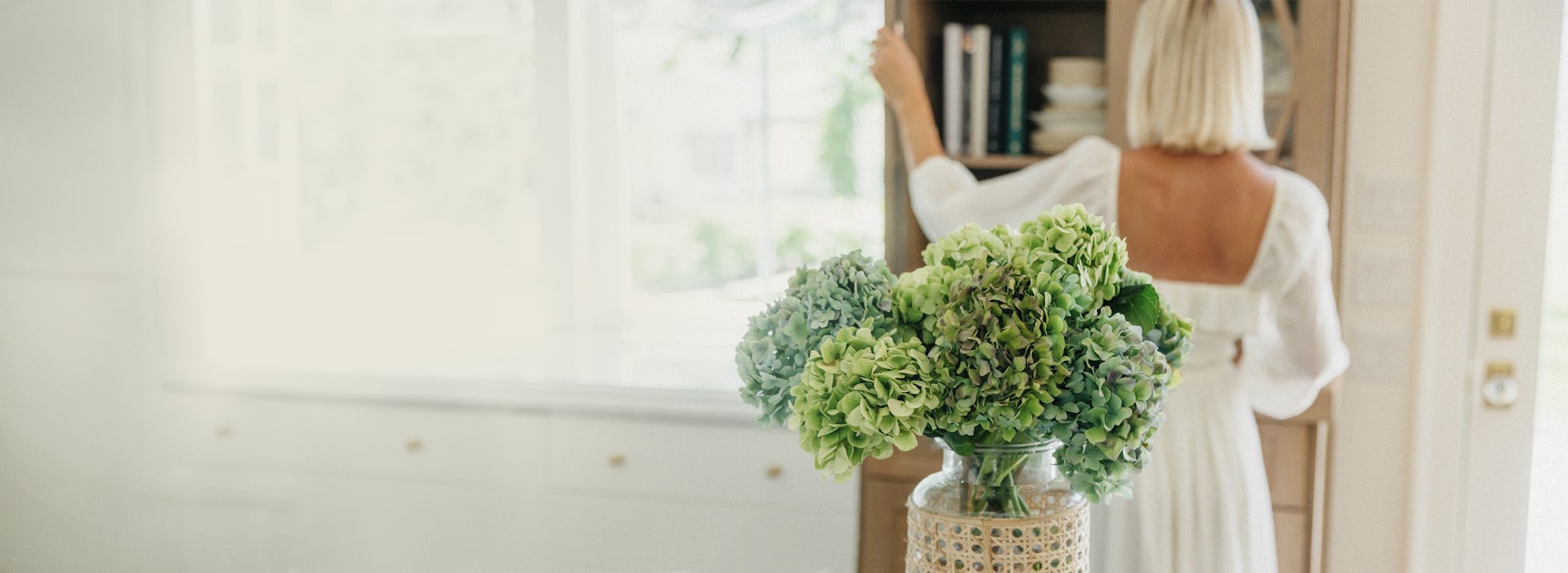 A beautiful vase of green hydrangeas on a table, enhancing a serene indoor atmosphere.