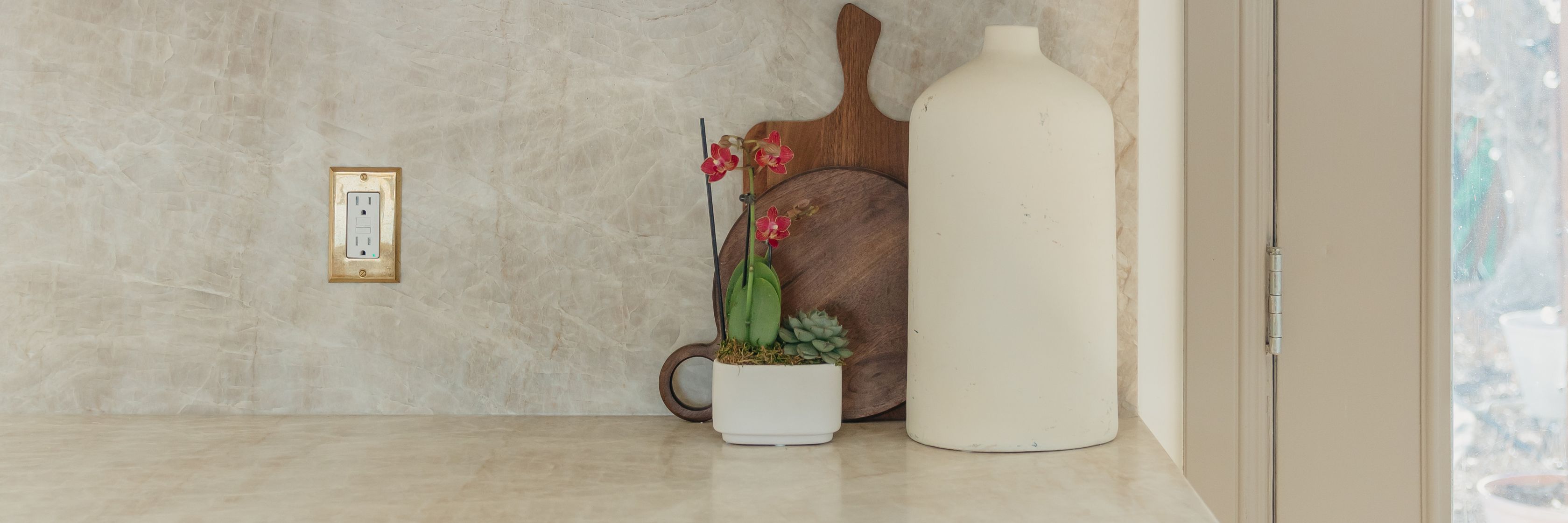 A serene kitchen countertop featuring orchids and modern decor elements in a stylish arrangement.