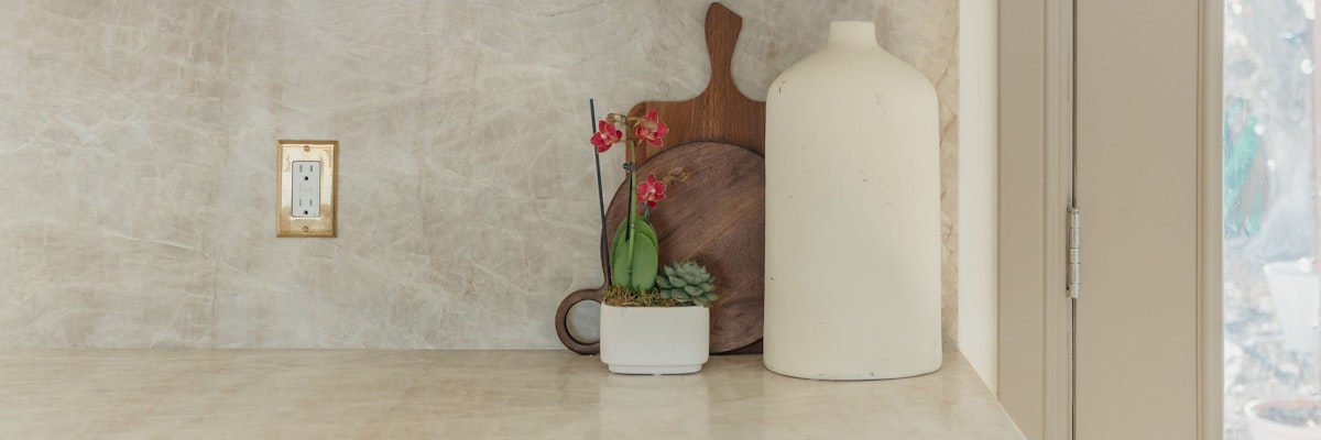 A serene kitchen countertop featuring orchids and modern decor elements in a stylish arrangement.
