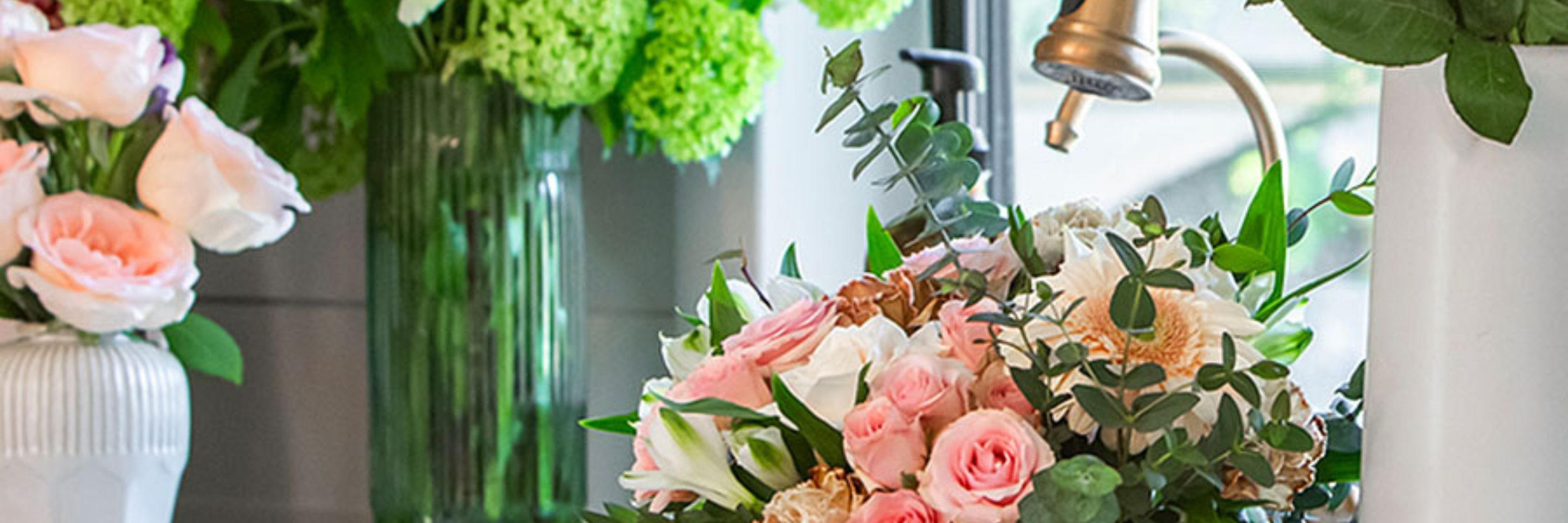 Charming floral arrangement featuring soft pink roses and greenery in a stylish vase.