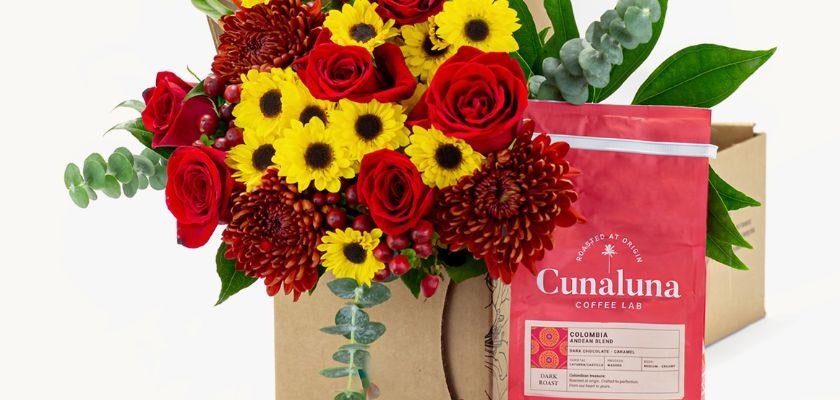 Vibrant floral arrangement of red roses and yellow daisies with a coffee blend package beside it.